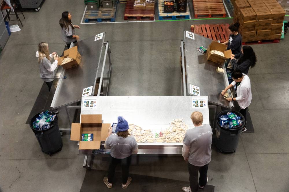 Birds eye view of a group of people loading food into cardboard boxes